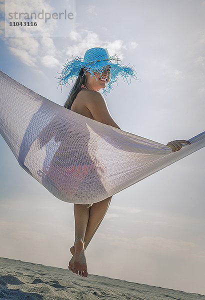 Kaukasische Frau in Hängematte am Strand