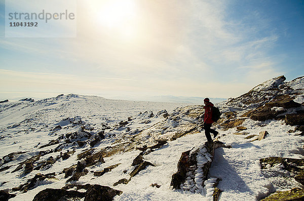 Mann beim Wandern auf einem Berg im Winter