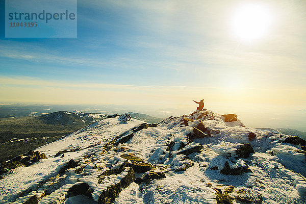 Frau sitzend auf Berg im Winter