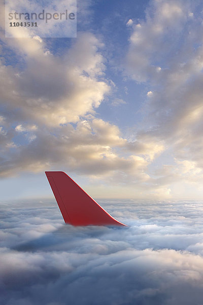 Ruder eines Flugzeugs über den Wolken
