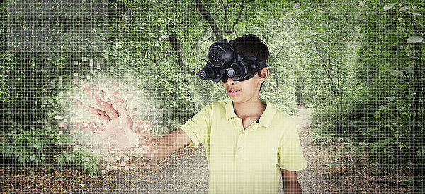 Gemischtrassiger Junge trägt Virtual-Reality-Brille in abgelegenem Wald