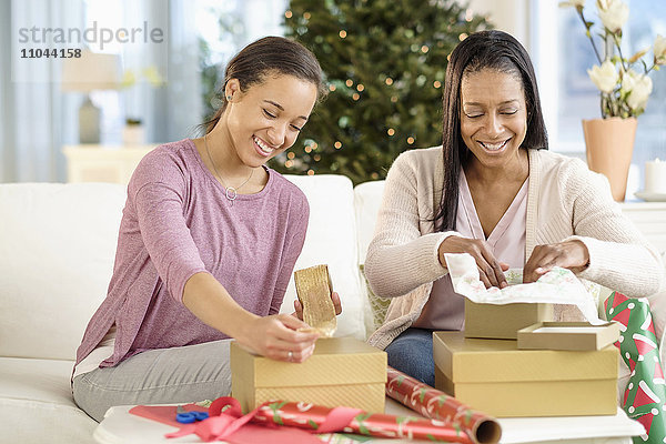 Mutter und Tochter verpacken Weihnachtsgeschenke