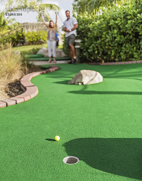 Kaukasisches Paar spielt Minigolf