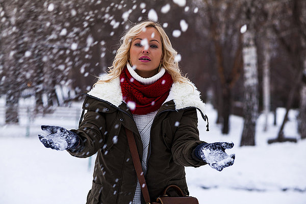 Kaukasische Frau spielt im Schnee