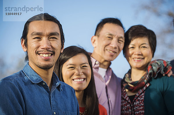 Chinesische Familie lächelt im Freien