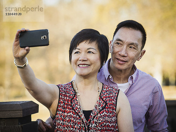 Älteres chinesisches Paar macht Selfie im Freien
