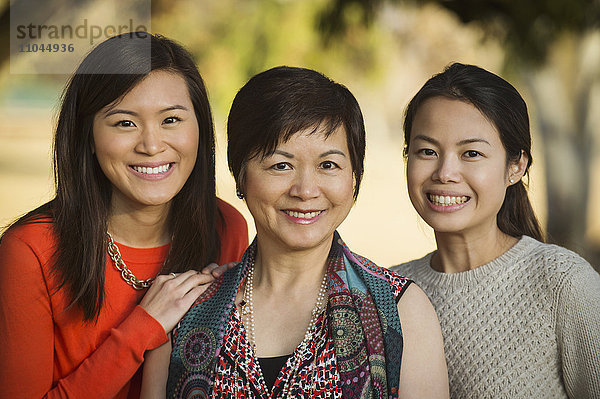 Chinesische Mutter und Töchter posieren im Freien