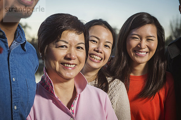 Chinesische Familie lächelt im Freien