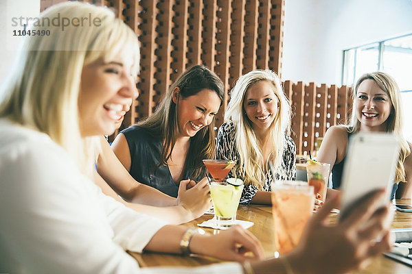 Kaukasische Frauen an der Bar mit Cocktails machen Selfie