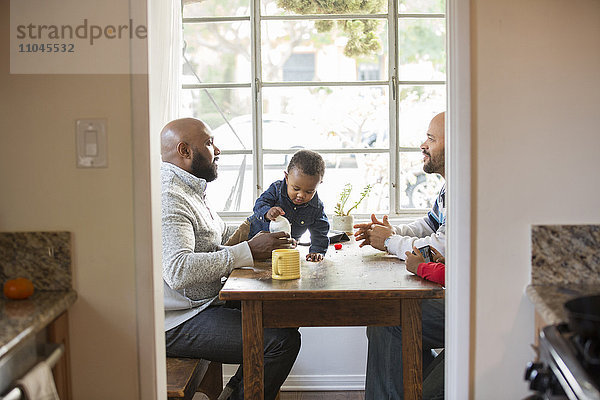 Väter und Kinder sitzen am Tisch