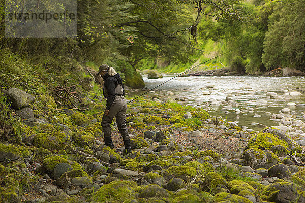 Kaukasische Frau  die in einem abgelegenen Fluss spazieren geht