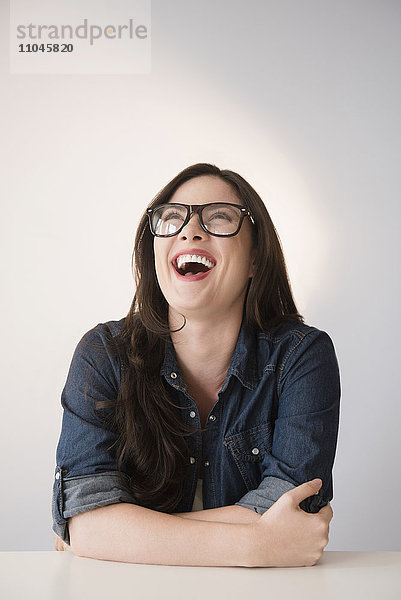 Kaukasische Frau mit Brille lachend