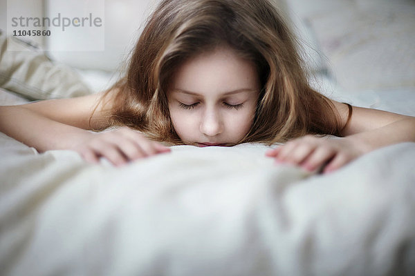 Kaukasisches Teenager-Mädchen auf dem Bett liegend