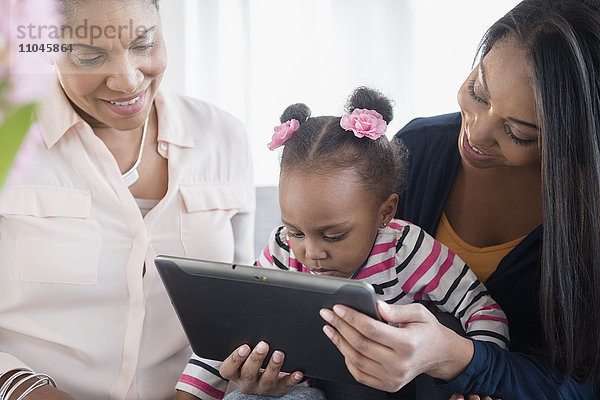 Schwarze Mehrgenerationenfamilie mit digitaler Tafel