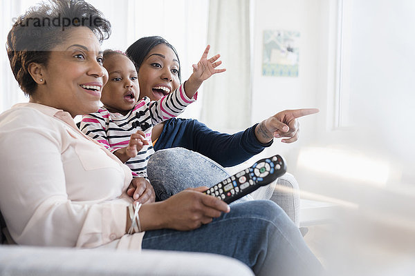 Schwarze Mehrgenerationenfamilie beim spannenden Fernsehen