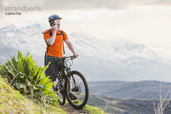 Kaukasischer Mann fährt Mountainbike  ruht sich aus und trinkt Wasser