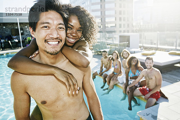 Lächelnde Freunde genießen das städtische Schwimmbad