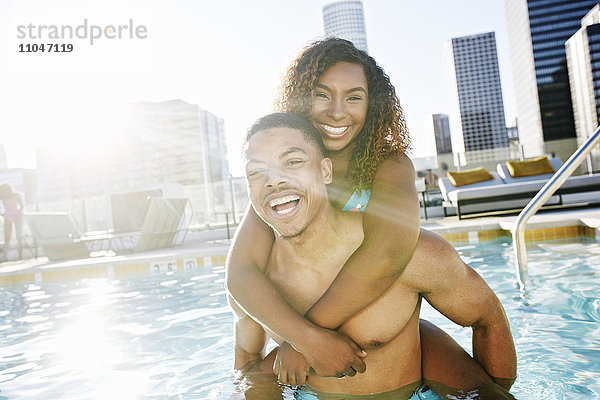 Lächelndes Paar genießt städtisches Schwimmbad