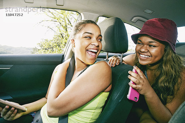 Mixed Race Schwestern lachen im Auto