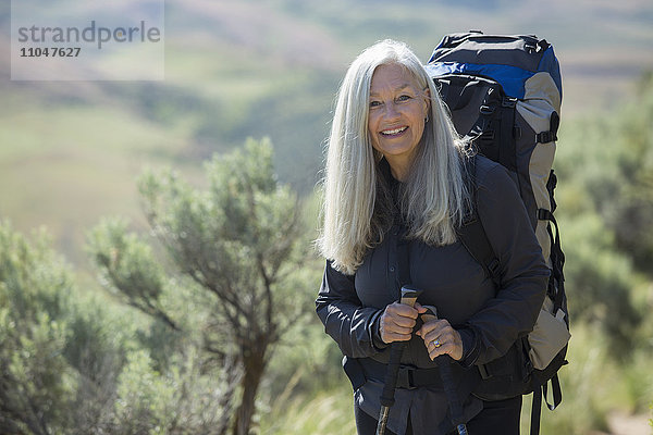 Ältere kaukasische Frau beim Wandern mit Rucksack
