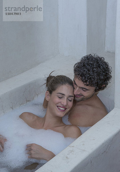 Lächelndes kaukasisches Paar entspannt sich in der Badewanne