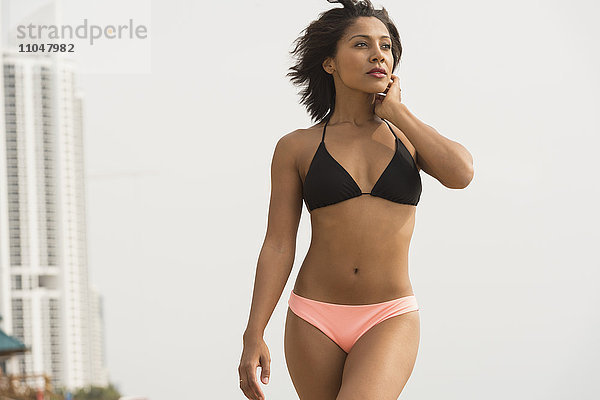 Afroamerikanische Frau im Bikini am Strand