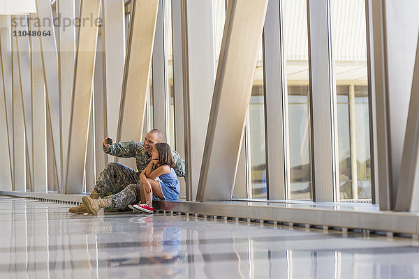 Heimkehrender Soldat macht Selfie mit Tochter am Flughafen