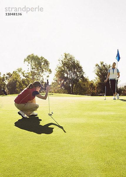 Kaukasische Frauen spielen Golf auf dem Golfplatz