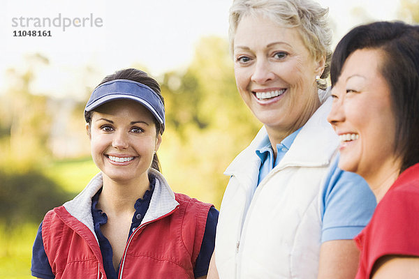 Lächelnde Frauen auf dem Golfplatz