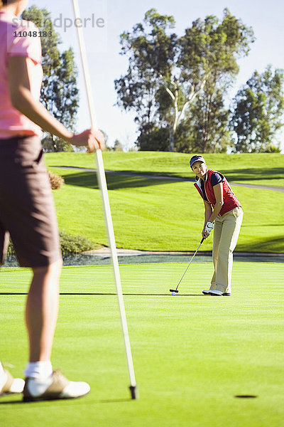 Frauen beim Putten auf dem Grün eines Golfplatzes