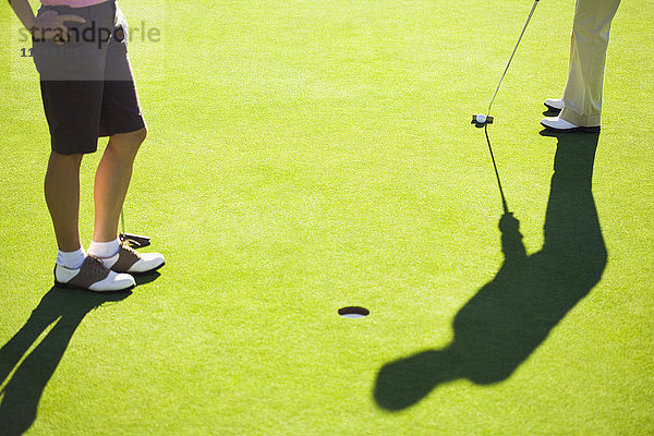 Frauen beim Putten auf dem Grün eines Golfplatzes