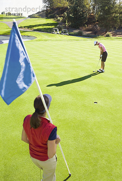 Frauen beim Putten auf dem Grün eines Golfplatzes