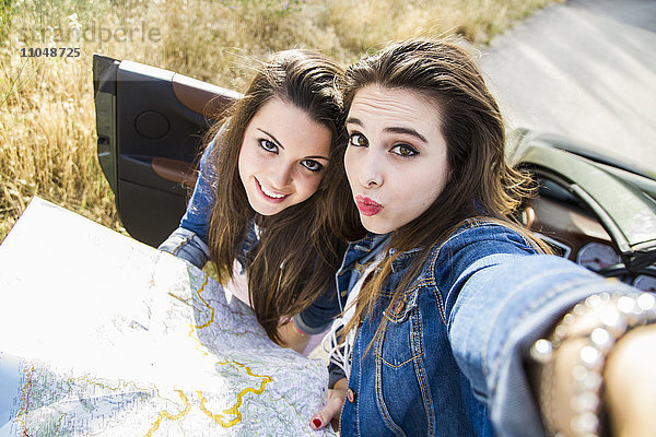 Frauen nehmen Selfie mit Karte auf Road Trip