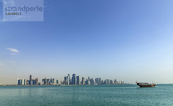 Boot schwimmt nahe der Skyline von Doha  Doha  Katar