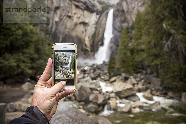 Mann fotografiert Wasserfall im Yosemite-Nationalpark  Kalifornien  Vereinigte Staaten