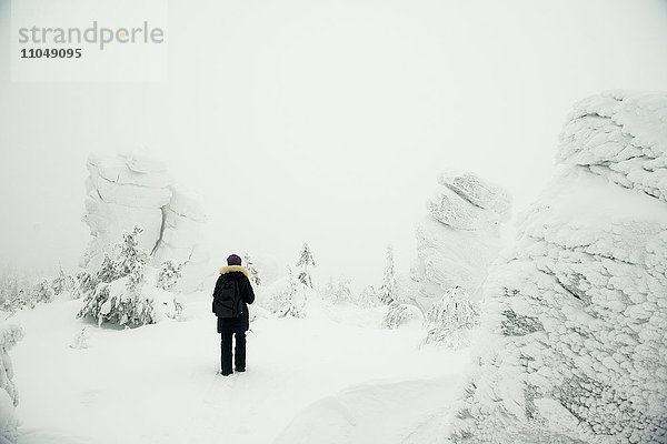 Wanderer im verschneiten Wald stehend