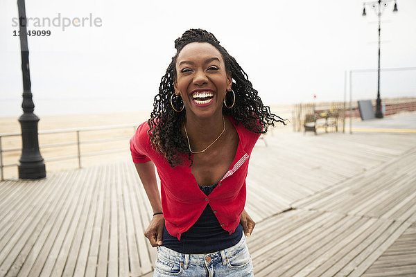 Schwarze Frau lachend auf der Strandpromenade