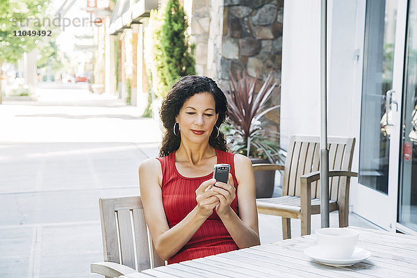 Mixed Race Frau texting auf Handy im Café