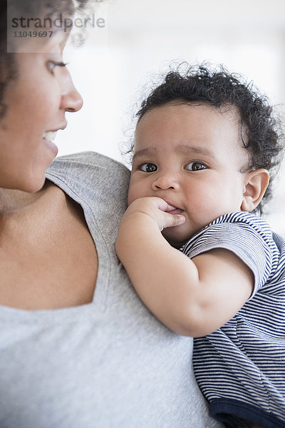 Mutter hält zahnendes Baby im Arm