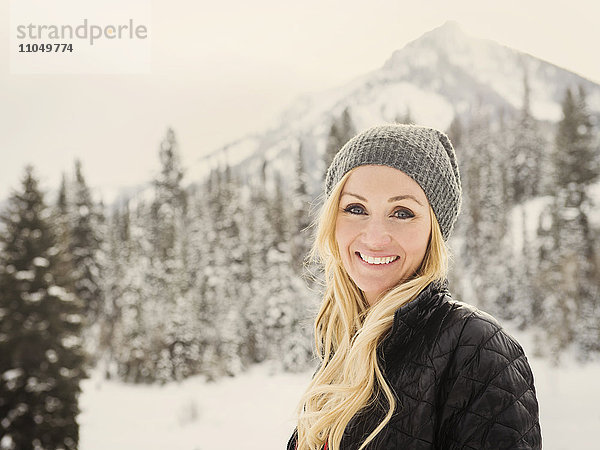 Kaukasische Frau lächelnd im Schnee