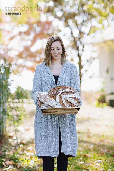 Kaukasische Frau hält Brot im Freien