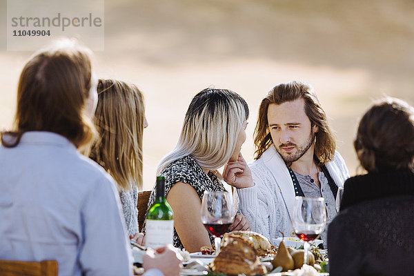 Freunde essen am Tisch im Freien