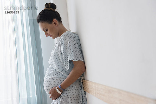 Schwangere kaukasische Frau im Krankenhauskittel