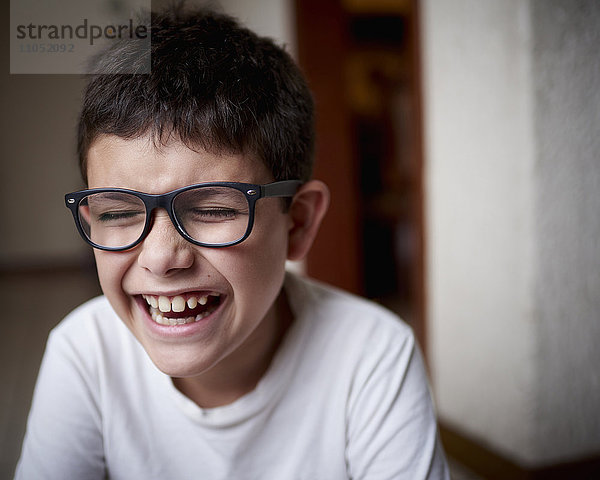 Lachender hispanischer Junge mit Brille