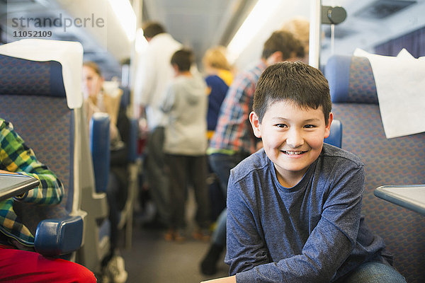 Hispanischer Junge lächelt im Zug