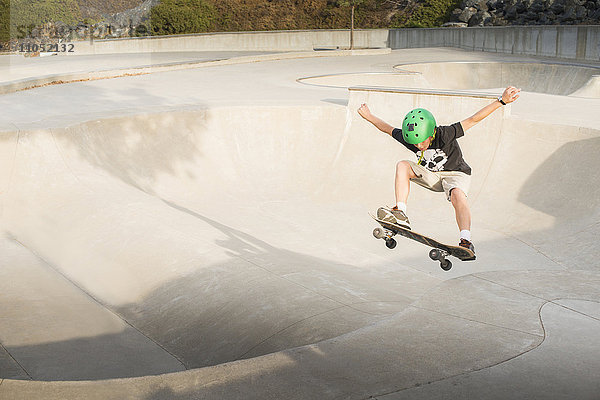 Gemischtrassiger Junge auf dem Skateboard im Skatepark