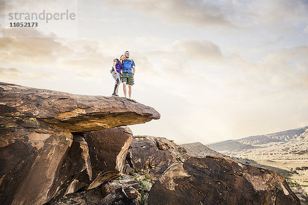 Kaukasisches Paar auf einer Felsformation und bewundert die Landschaft