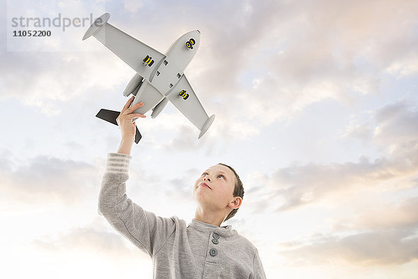 Kaukasischer Junge fliegt Spielzeugflugzeug