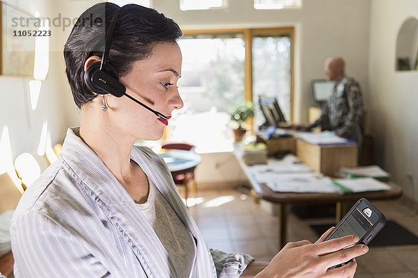 Geschäftsfrau mit digitalem Tablet und Headset im Büro