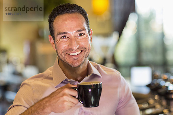 Hispanischer Barista trinkt Kaffee im Coffeeshop